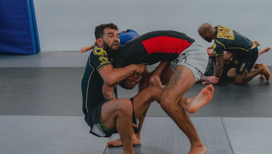 Pratiquants de grappling au sol sur tatami